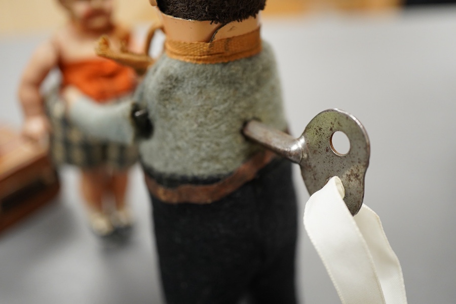 A Gescha, DRGM (Germany), clockwork tinplate acrobatic bellboy on ‘Express’ trunk, together with a Schuco, Germany tinplate and cellulose clockwork man with girl automaton